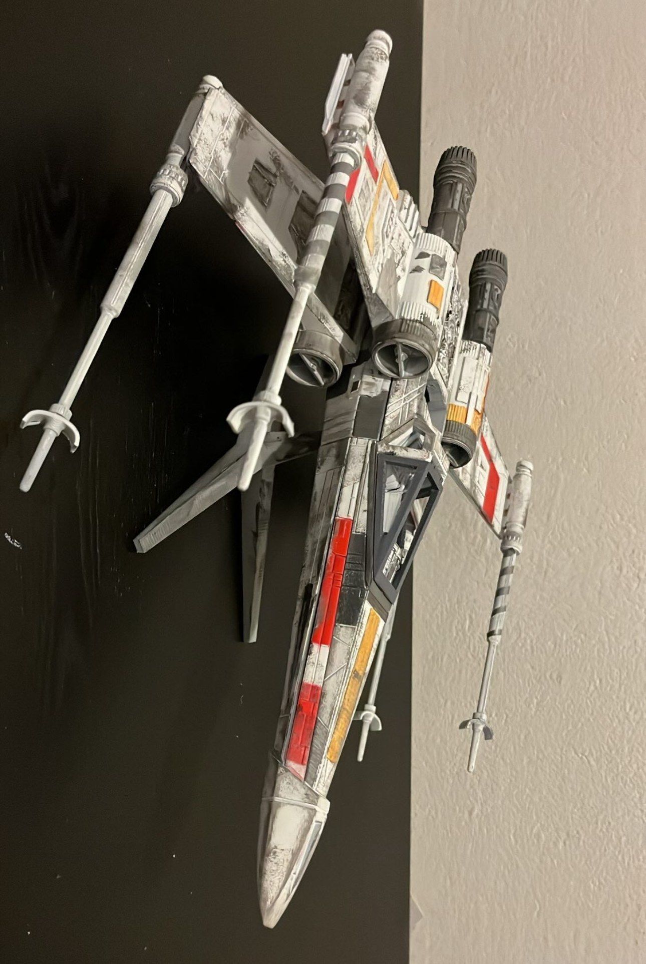 The X-wing mounted on a dark wall, seen from above
