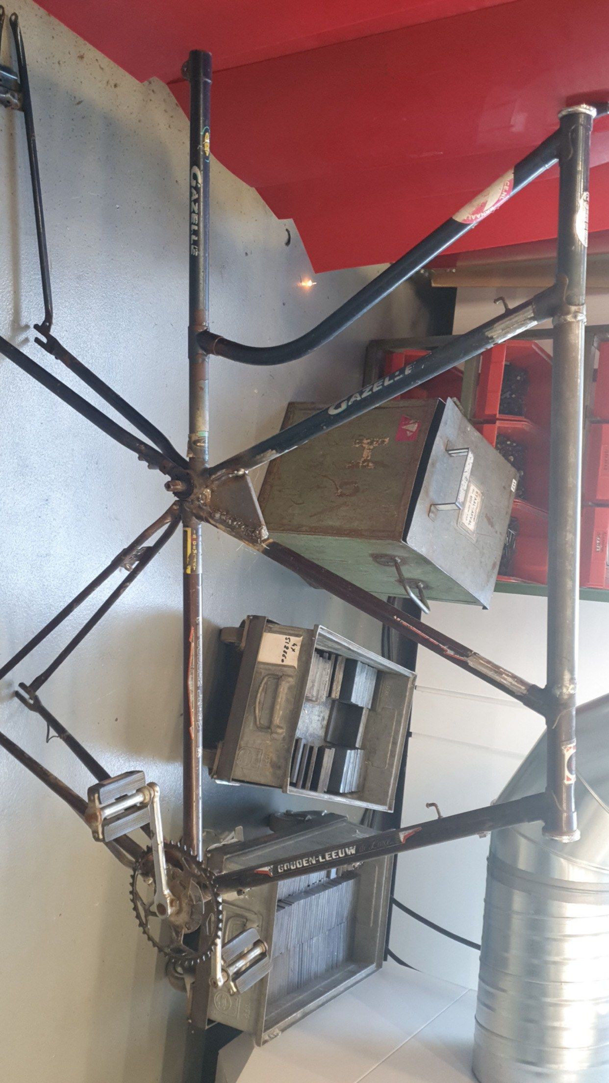 The stacked frame hanging on a workshop wall before wheels went on