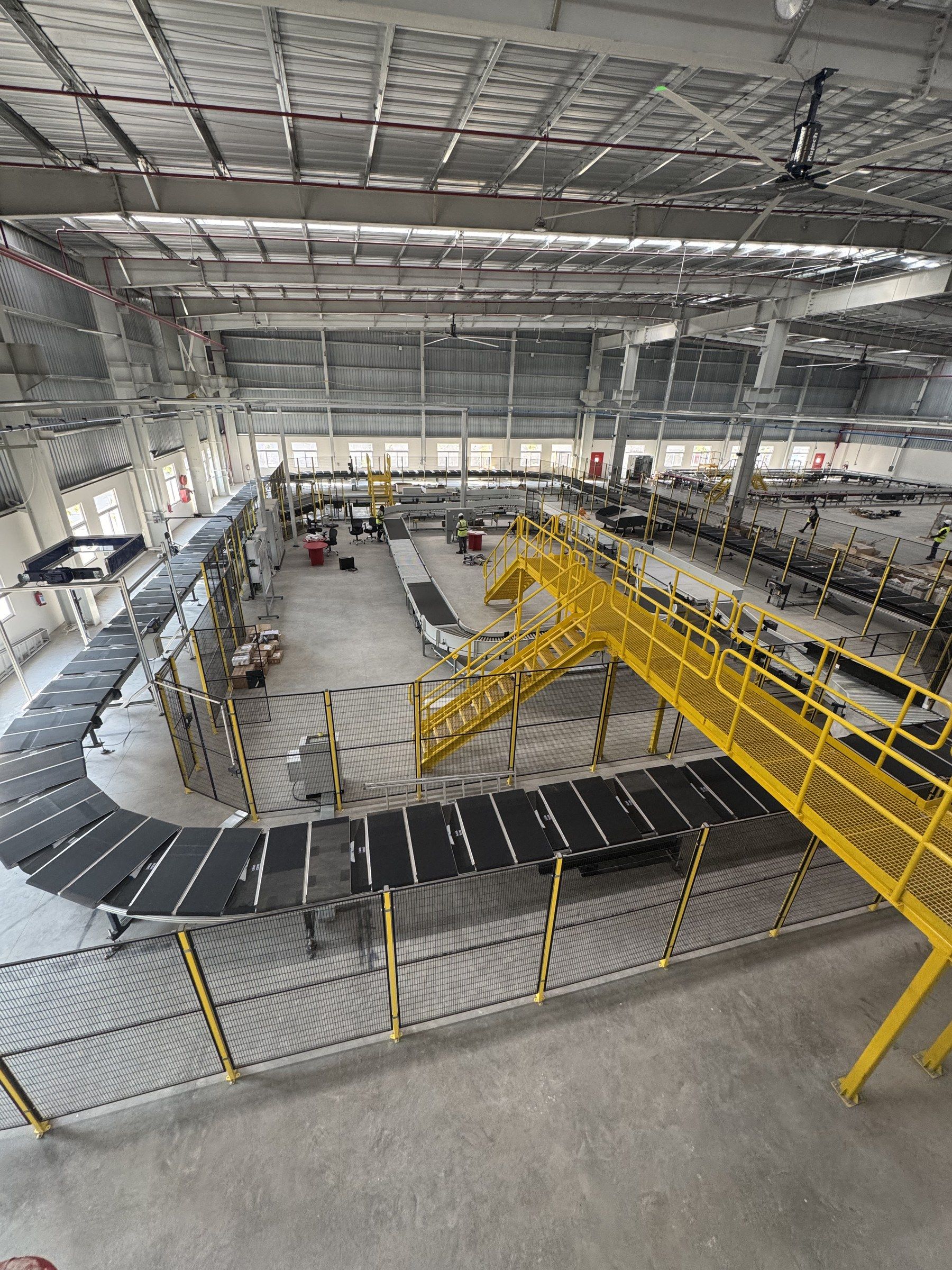 A loop sorter snaking through a new distribution centre in India, seen from a mezzanine