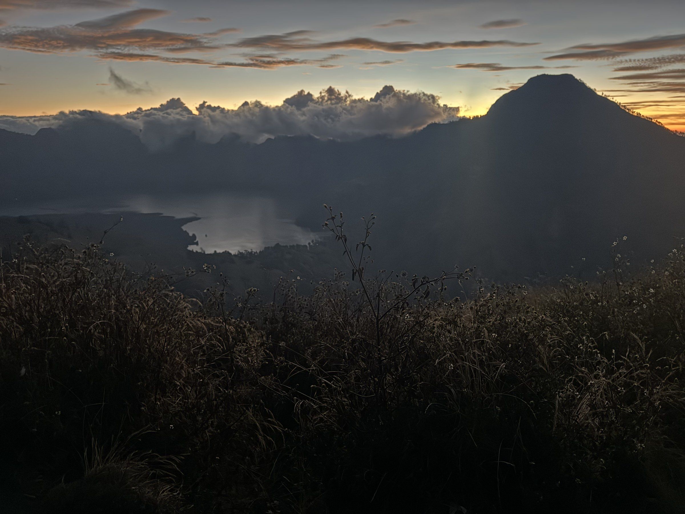 Rinjani crater lake at dusk, surrounded by jagged peaks