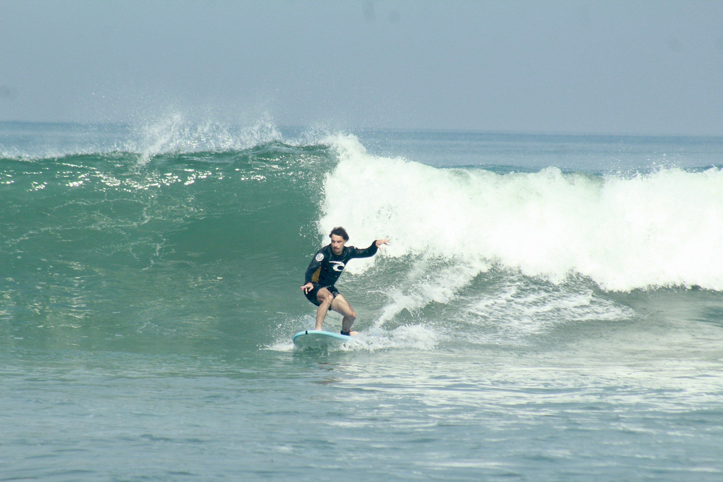 Orhun surfing along the face of a green wave in Indonesia