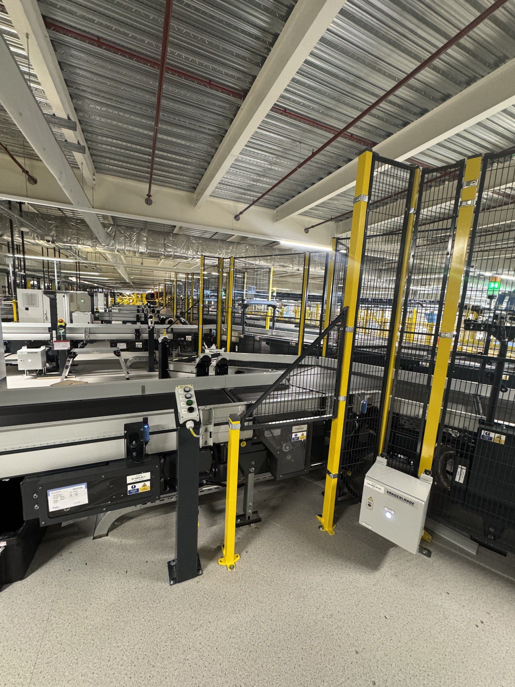 A long sorter line in a UK distribution centre with yellow safety posts