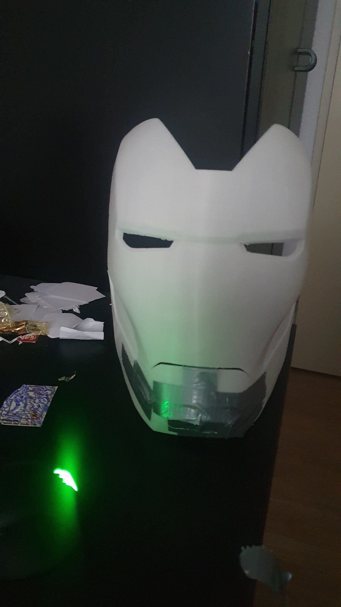 Assembled white helmet with a green LED glowing behind it
